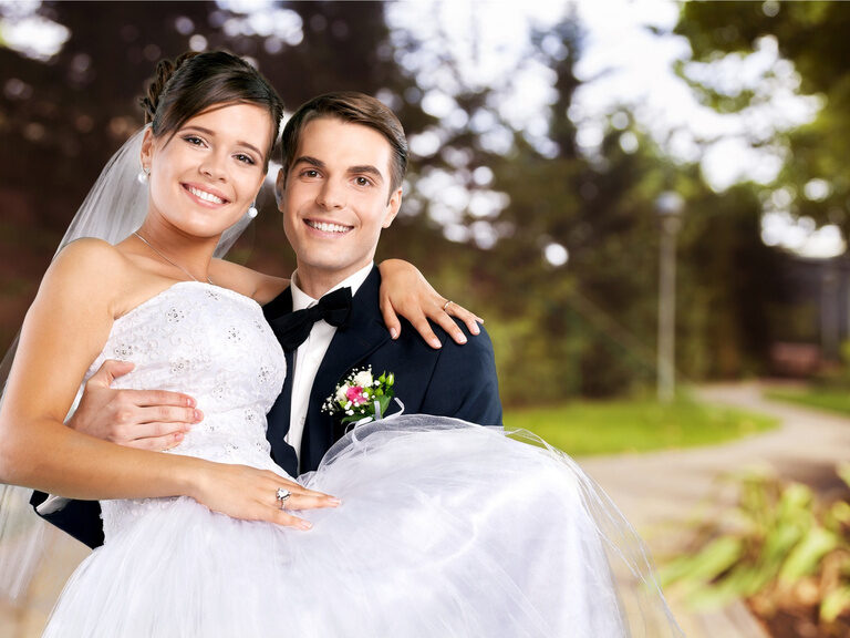 Ein Bräutigam trägt die Braut